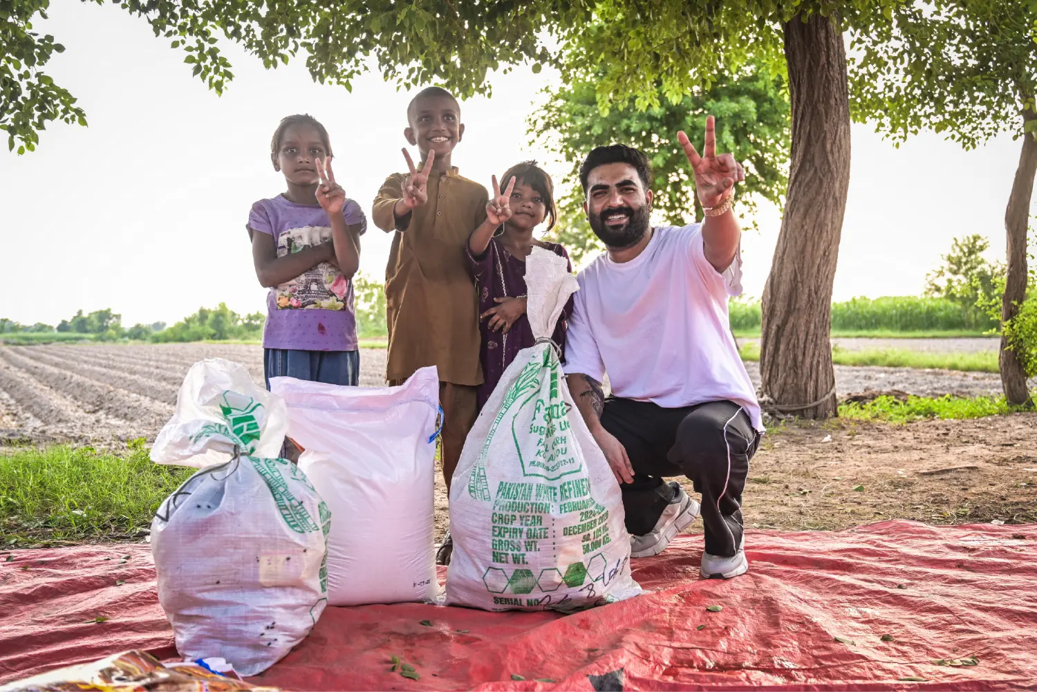 Children with their rations and Pastor Ashkar Javed