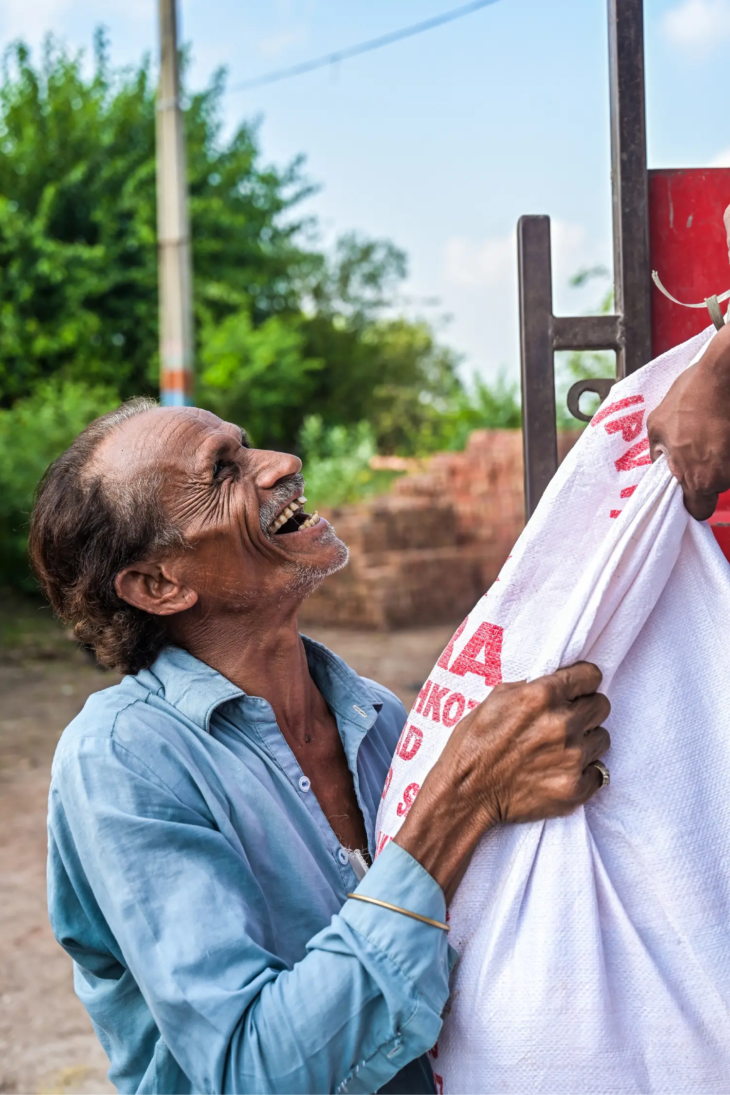 An elderly man laughing with joy as he receives his food ration
