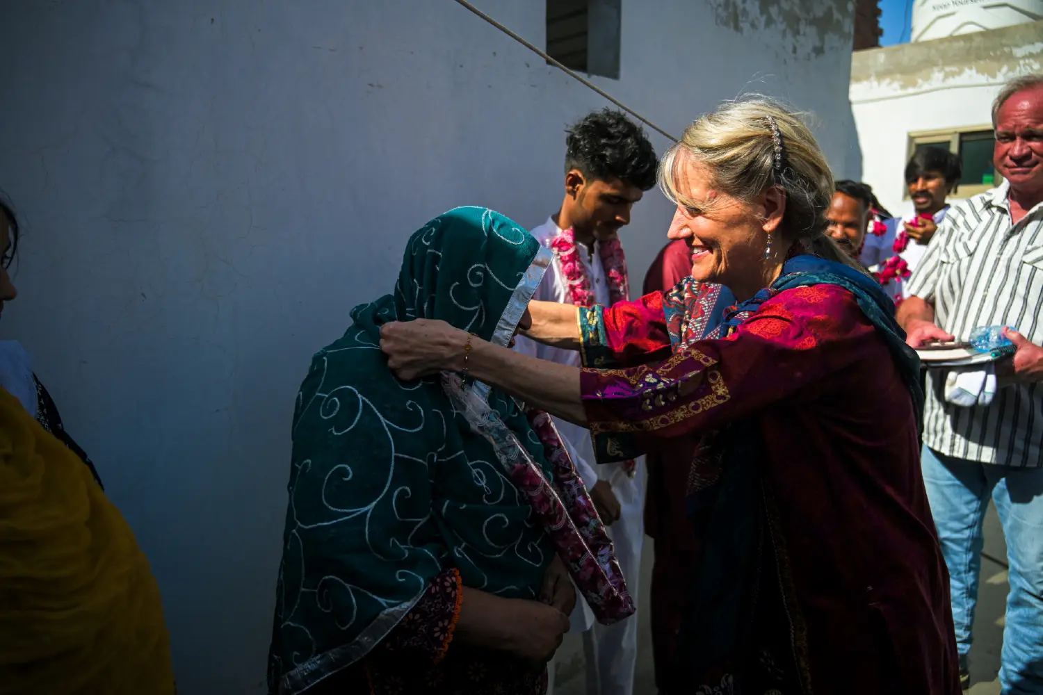 President Ruth King welcoming new believers with flower garlands