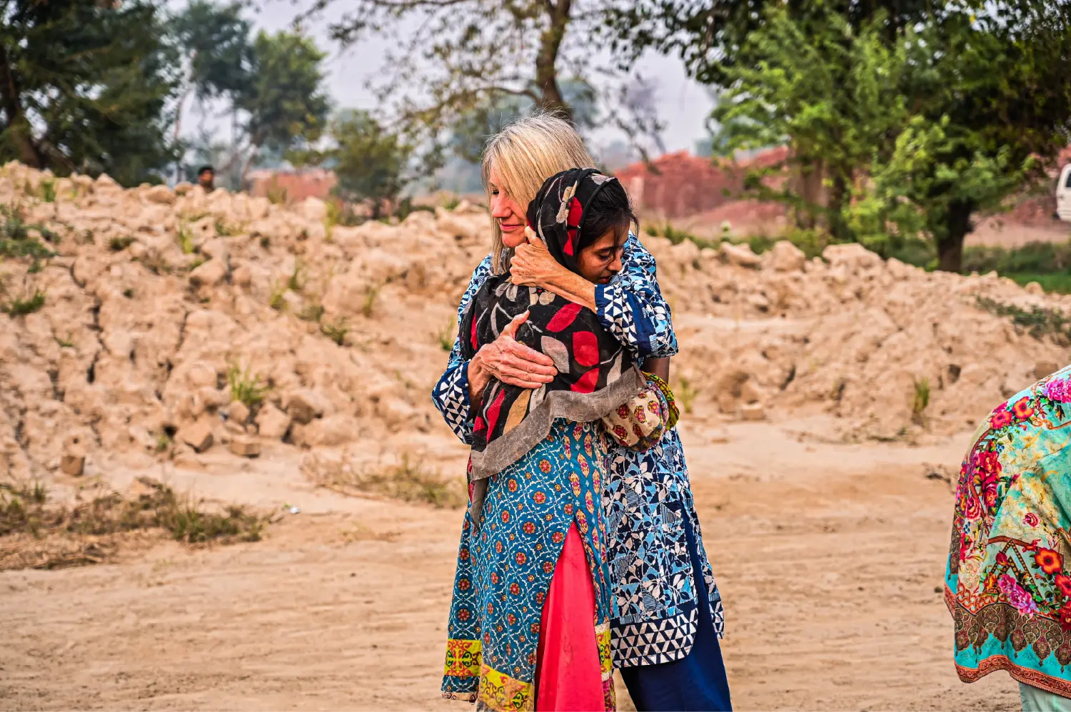 President Ruth King hugging a girl at the brick kiln