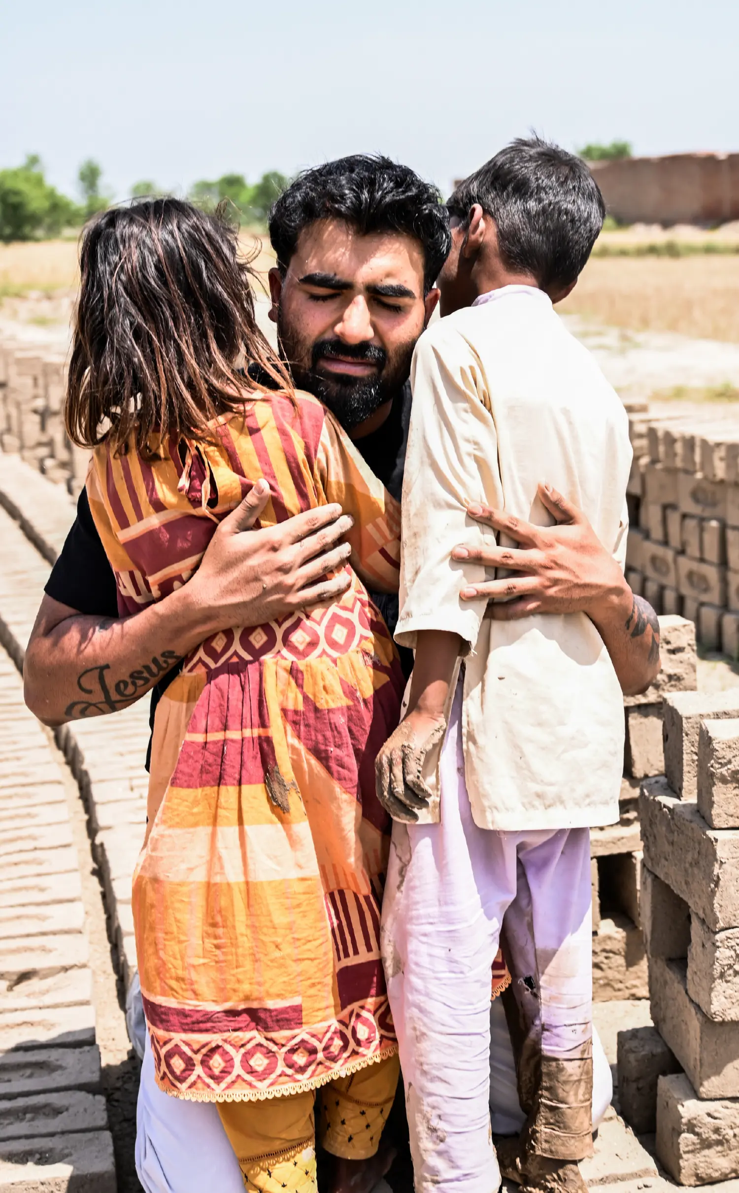Pastor Bobby hugging two children while rescuing them