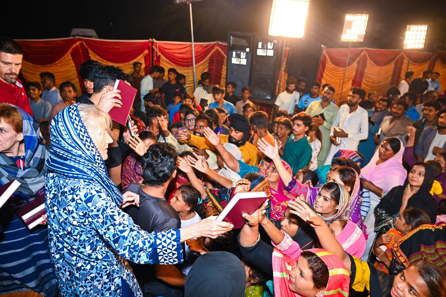 President Ruth King distributing Holy Bibles as people gather to receive them