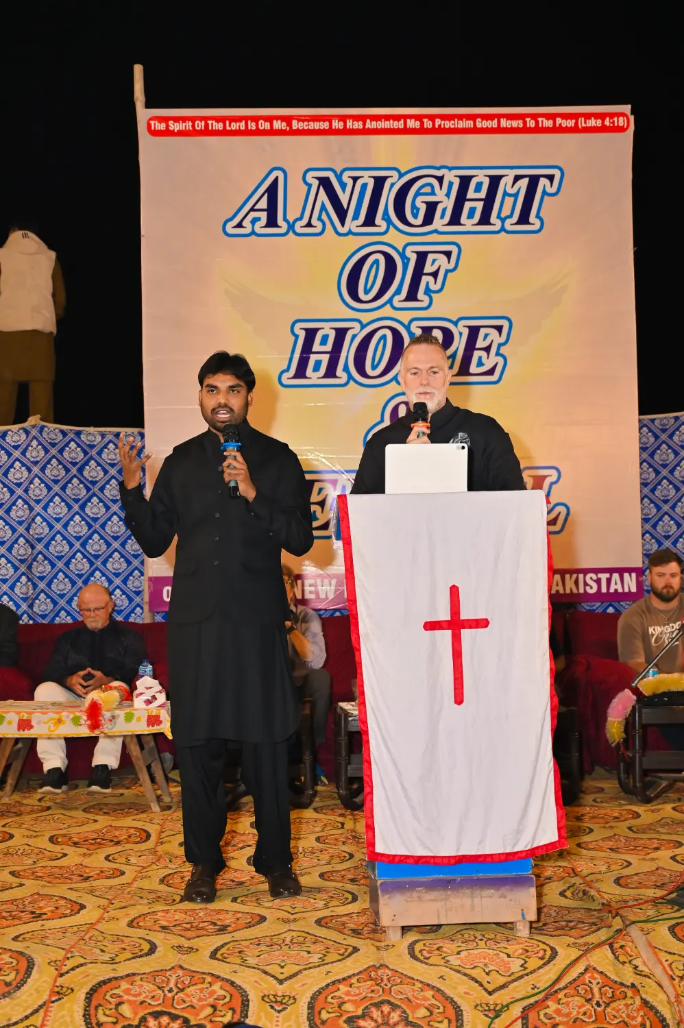 Pastor Suryani Javed and Pastor Mark preaching at a crusade