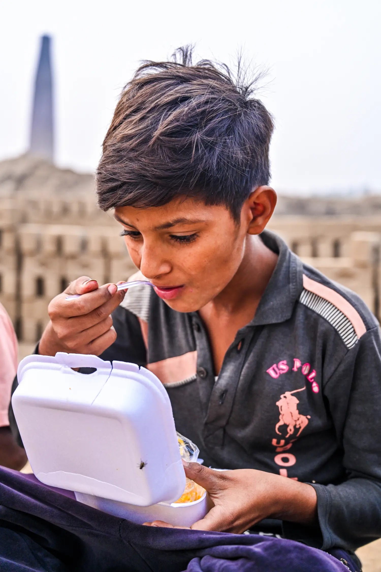 A Boy Eats After Drinking Clean Water