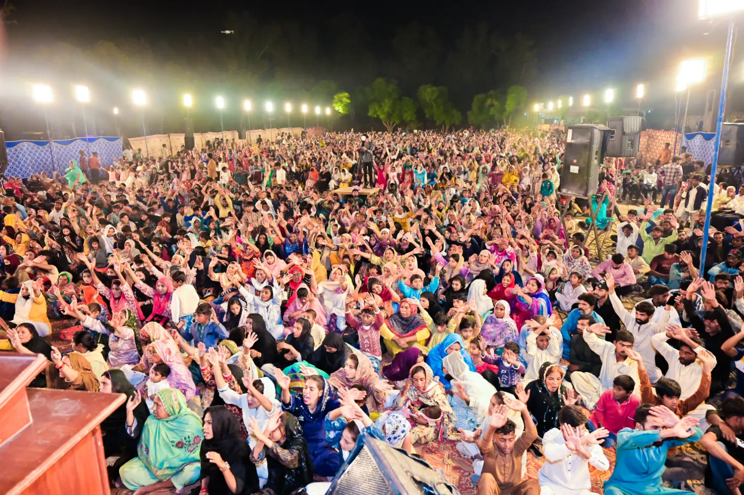 Worshippers with hands raised at a prayer festival