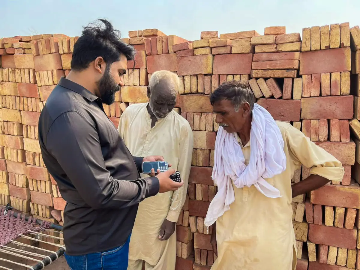 Pastor Ashkar distributing audio Bibles among brick kiln laborers